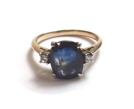 A gold, sapphire and diamond set three stone ring, claw set with the oval cut sapphire at the centre, between two circular cu