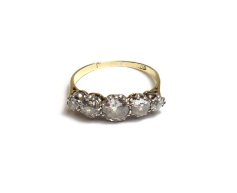 A gold and platinum, diamond set five stone ring, claw set with a row of cushion shaped diamonds graduating in size to the ce