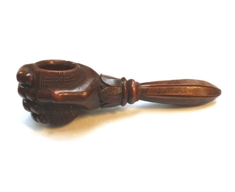 A novelty yew wood nut cracker, late 19th century/early 20th century, carved as a hand holding a cup with foliate collar and 