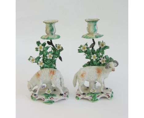 A pair of Bow models of sheep, circa 1765, each standing before a flowering tree on a scroll moulded base, each adapted as a 