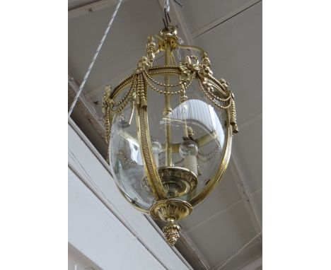An English brass hall lantern, first half 20th century, with curved glazed panels (one a.f). The frame moulded and cast with 