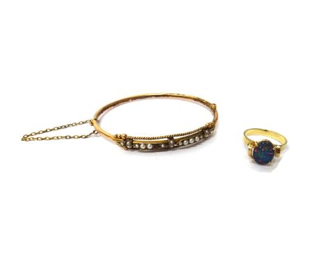 A gold and seed pearl set oval hinged bangle, on a snap clasp and a gold ring, mounted with an oval opal doublet, detailed 9 