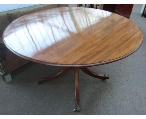 A Regency mahogany oval snap top centre table on four downswept supports, 110cm x 127cm.