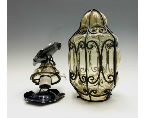 A wrought iron and blown amber glass light fitting, 20th century, height 43cm and another similar (2).Condition report: No co