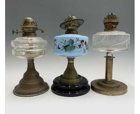 A Victorian oil lamp with blue glass floral painted reservoir, height 33.5cm, and two other oil lamps (3)
