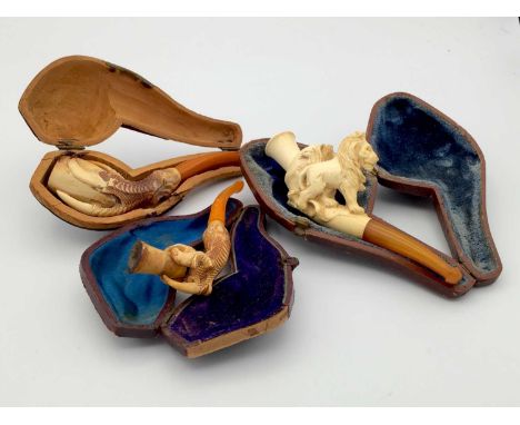 A Meerschaum pipe, 19th century, carved with a seated lion, length 10cm, cased, together with two further 19th century pipes,