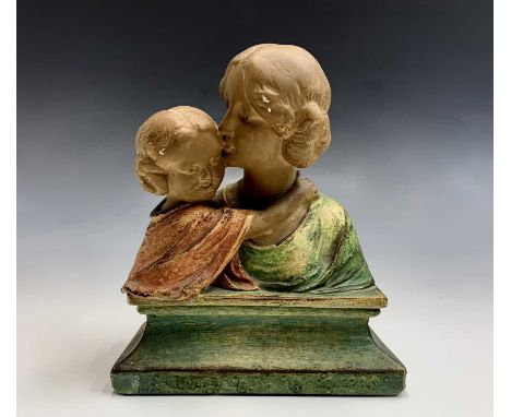 An Arts and Crafts plaster bust, modelled as a Pre Raphaelite style mother and child on a plinth base, indistinct applied mar