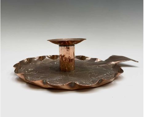 An Arts and Crafts copper chamber candlestick, repousse decorated with four fish, the tail of one forming the handle, width 2