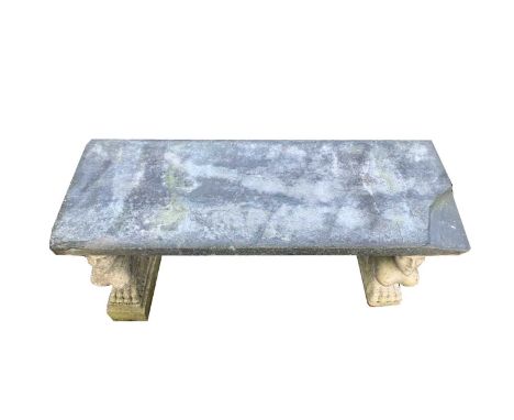 A Garden bench, the associated stone top raised on a pair of composite stone supports cast as sphinxes. Length 106cm.