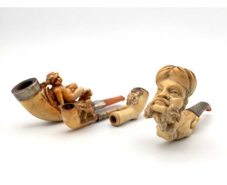 A Meerschaum pipe, 19th century, carved with the head of a Turk and a woman, length 11cm, two other pipes, and a small pipe b