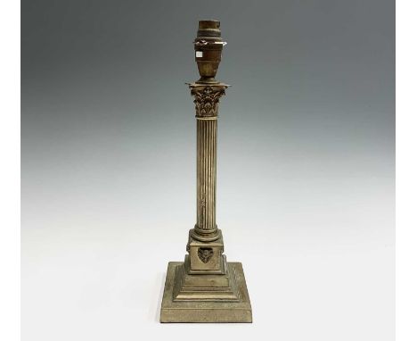A brass Corinthian column table lamp base, with applied mask decoration to the pedestal. Height 35cm.