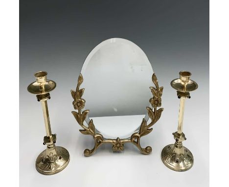 A gilt metal mounted easel mirror, with floral and leaf decoration, height 34cm and a pair of brass candlesticks, with red st