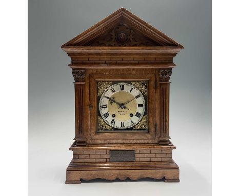 An Edwardian walnut architectural cased mantel clock, the German movement with silvered chapter ring and pierced gilt spandre