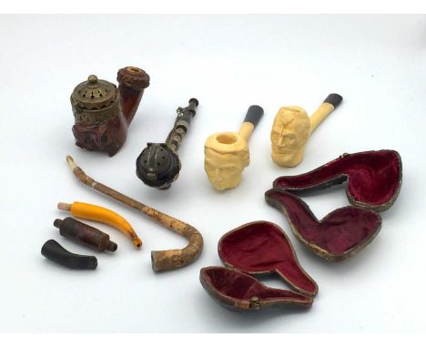 A burr wood pipe bowl, 19th century, carved with a man wearing a hat, together with a metal pipe, mounted with stars and a co