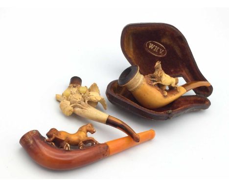 A Meerschaum pipe, 19th century, carved with two horses, length 10cm, cased, a cheroot holder carved with a horse, and anothe