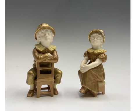 A pair of Royal Worcester shot silk figures of children, late 19th century, after Hadley, the boy seated backwards on a chair