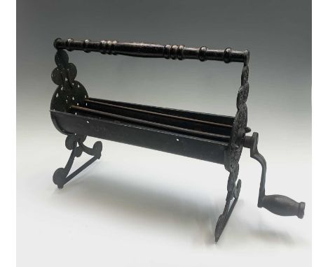 A vintage cast iron and metal newspaper log roller, length 56cm.