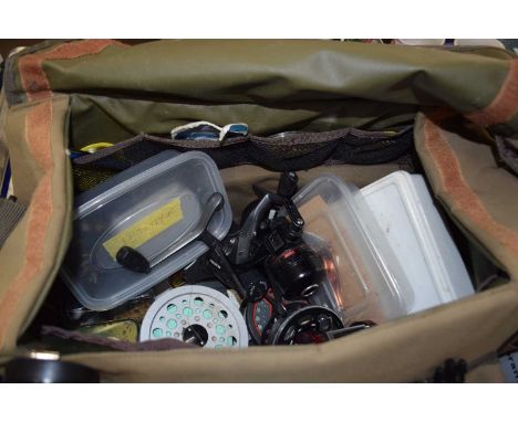 A Wychwood fishing tackle bag together with a quantity of fishing reels and equipment