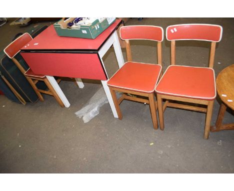 A vintage red melomine topped drop leaf kitchen table and three chairs
