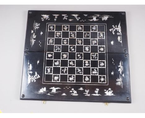 A Japanese? ebonised and mother-of-pearl inlaid chess and backgammon board, 25" wide 