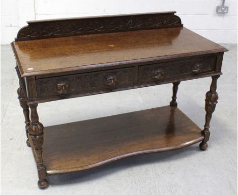 An early 20th century oak Green Man buffet, carved back rail above two frieze drawers with Green Man motifs, to turned balust