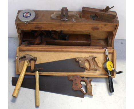 A vintage wooden toolbox containing vintage tools to include wooden planes, screwdrivers, hammers etc.