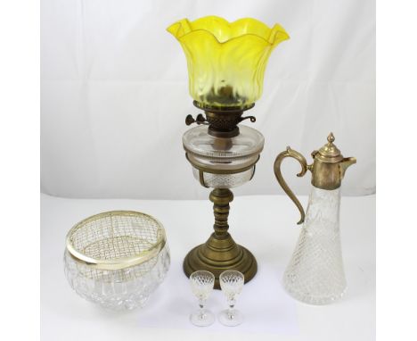 A vintage double burner paraffin lamp with averted yellow glass shade over cut glass reservoir supported on brass pedestal, a