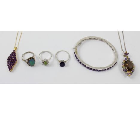 A silver bangle set with nineteen purple stones, a silver chain with silver pendant set with oval topaz-coloured stone and mu