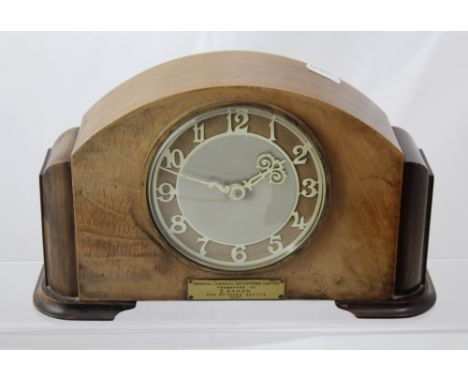 A mid 20th century Art Deco style mahogany cased mantel clock the silvered and wooden dial set with Arabic numerals, brass pl