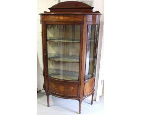 An Edwardian mahogany bow front display cabinet with architectural backrail and three panel curved glass front with two velve