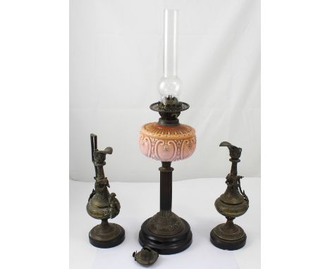 An Edwardian pedestal paraffin lamp with peach latte glass reservoir and smoke stack, height 70cm and brass jug garniture (3)
