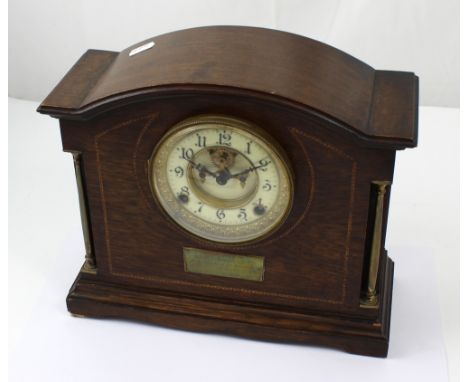An early to mid 20th century oak cased Ansonia dome topped eight day mantel clock the ceramic dial set with Arabic numerals, 