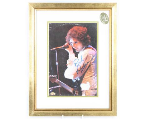 Bob Dylan, a 29.5 x 19.5cm colour image of Dylan with guitar and microphone before him, bears signature in blue ink, with Spo