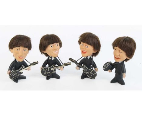 The Beatles, a set of four plastic figures, each modelled in a black suit and tie, John, Paul and George each with a guitar, 