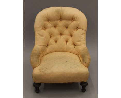 A peach upholstered button back nursing chair. 59 cm wide.