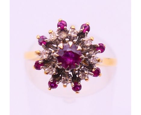 An 18 ct gold, ruby and diamond cluster set ring.  Ring size M.