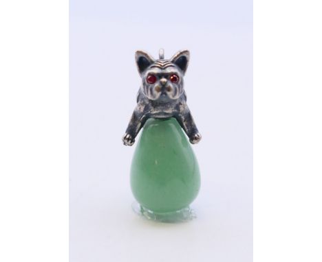 A jade pendant in the form of a dog astride an egg, bearing Russian marks.  3 cm high. 