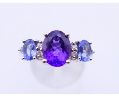 A 14 ct white gold, amethyst and topaz ring.  4.9 grammes. Ring size Q/R.