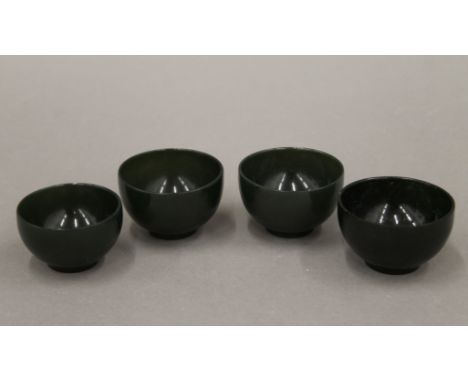 A set of four Oriental jade wine cups. 5 cm diameter.