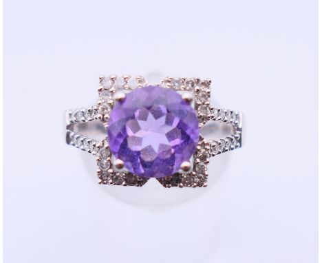 A 9 ct white gold, amethyst and diamond ring.  4.4 grammes. Ring size Q/R.