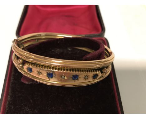 A 9 ct gold bangle inset with sapphire and diamonds fitted in box .total weight 10.5 grams.