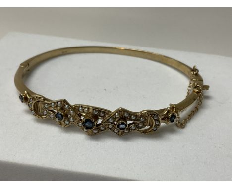 An Edwardian 9ct gold sapphire and seed Pearl bangle. Approx 14g.