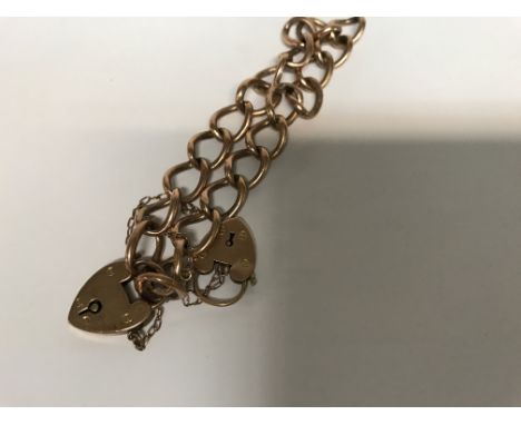 A 9 ct gold gate bracelet with heart clasp .