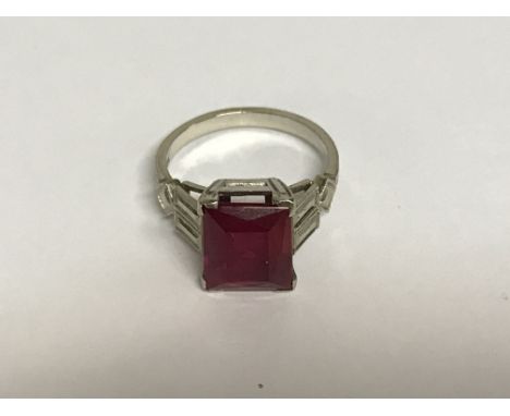 A white ring marked 14 k inset with central red stone . J/k .