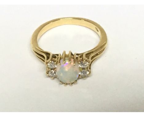 An 18carat gold ring set with a central Opal flanked by four brilliant cut diamonds. Weight 3.4g ring size k