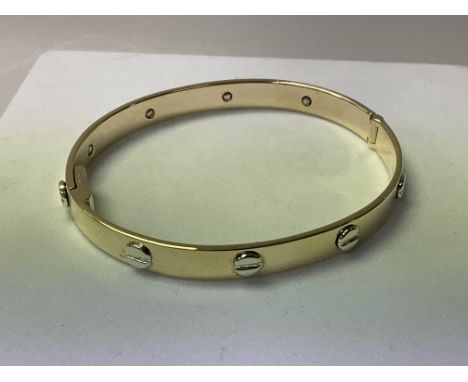 A 9ct gold Cartier style bangle approximately 20g.