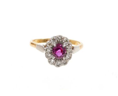 Ruby and diamond cluster ring with an oval mixed cut ruby surrounded by a border of single cut diamonds in platinum setting o