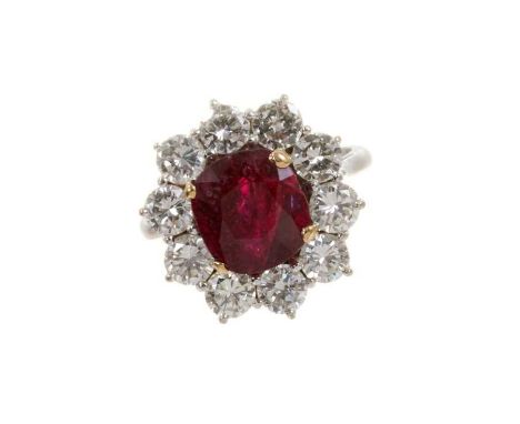 Ruby and diamond cluster ring with an oval mixed cut ruby measuring approximately 9.1mm x 8.3mm x 6.1mm surrounded by a borde