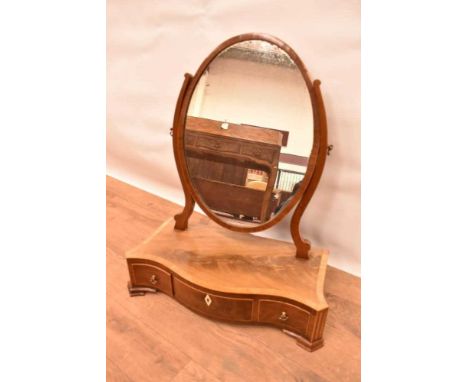 Regency mahogany and tulipwood crossbanded toilet mirror, with oval hinged plate raised serpentine platform base with three f