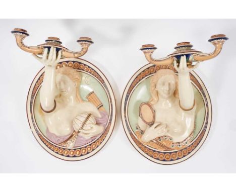 A rare pair of Victorian majolica wall sconces, probably Minton, the oval moulded wall plates with figures of Urania and Iaso